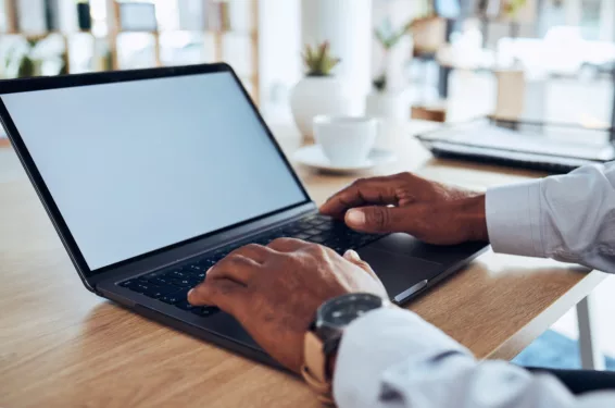 Mãos de um homem mexendo em um notebook