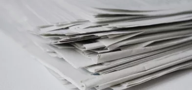 Pilha de papel ilustrando importância de economizar papel no setor público