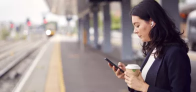 Mulher esperando trem em estação. Foto ilustrando importância da Mobilidade urbana sustentável