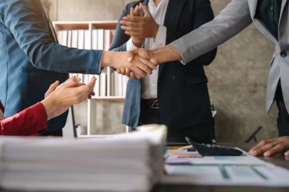 Pessoas apertando as mãos, em foto que ilustra post sobre contratações públicas.