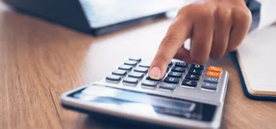 Pessoa usando calculadora, em foto que ilustra post sobre nudges fiscais.