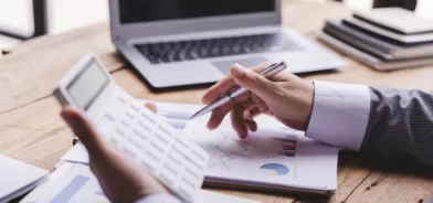 Pessoa fazendo contas em calculadora, em foto que ilustra post sobre reforma tributária