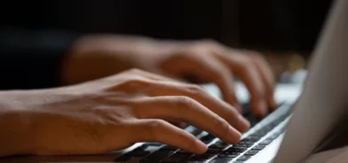 Pessoa digitando em computador, em foto que ilustra post sobre governança de dados.