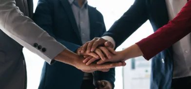 Pessoas de mãos dadas, simbolizando união e trabalho em conjunto, em foto que ilustra post sobre integridade pública. Foto: paegagz/envato