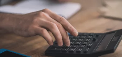 Homem usando calculadora, em foto que ilustra post sobre contabilidade municipal.