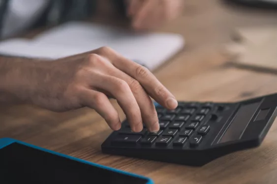 Homem usando calculadora, em foto que ilustra post sobre contabilidade municipal.