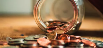 Jarro de vidro com moedas saindo, em foto que ilustra post sobre evasão fiscal. Foto: Josh Appel/Unsplash