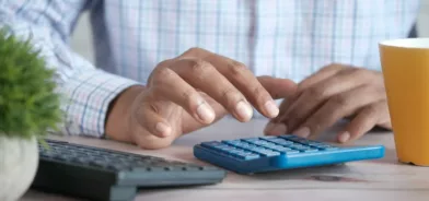Pessoa usando calculadora, em foto que ilustra post sobre justiça fiscal. Foto: Towfiqu barbhuiya/Unsplash