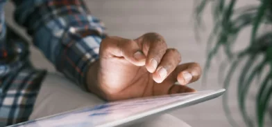 Pessoa usando tablet, em foto que ilustra post sobre contratos inteligentes. Reprodução: Towfiqu barbhuiya/Unsplash