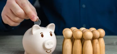 Pessoa colocando moeda em cofrinho, em foto que ilustra post sobre Lei Complementar 201/2023. Reprodução: iLixe48/Envato.