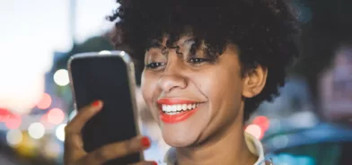 Mulher usando celular, em foto que ilustra post sobre autoatendimento em serviços públicos. Foto: peus80/Envato.