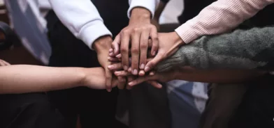 Pessoas com mãos próximas, simbolizando união. Foto ilustrando post sobre impacto social. Reprodução: Queenmoonlit3/Envato.