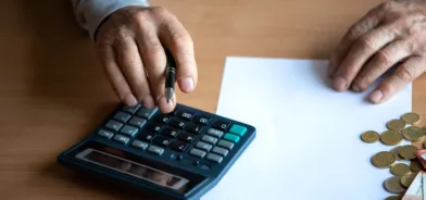 Pessoa usando calculadora, em foto que ilustra post sobre Lei de Responsabilidade Fiscal. Reprodução: zelmab/Envato.