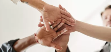 Pessoas estendendo as mãos, simbolizando união, confiança e trabalho coletivo. Foto que ilustra post sobre princípio da moralidade na administração pública. Reprodução: seventyfourimages/Envato.