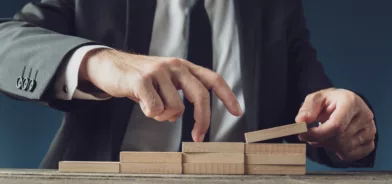 Homem de terno “subindo escadas” com dedo, em foto que ilustra post sobre IEGM. Reprodução: Gajus-Images/Envato.