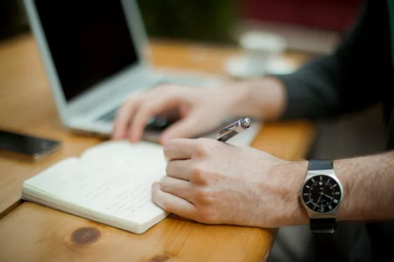 Homem estudando e anotando em caderno, foto que ilustra post sobre princípio da impessoalidade. Reprodução: Alejandro Escamilla/Unsplash.