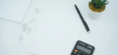 Calculadora, papel e clipes, ilustrando post sobre LDO. Reprodução: Mediamodifier/Unsplash