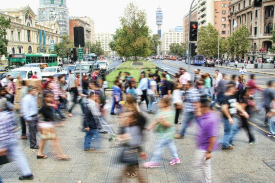 Pessoas atravessando a rua em Santiago, no Chile. Foto que ilustra post sobre coesão social. Reprodução: Mauro mora/Unsplash.