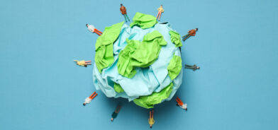 Representação artística da Terra, feita com camadas de papel amassado em tons de azul e verde, em um fundo azul liso. Foto que ilustra post sobre ISO 14001. Reprodução: AtlasComposer/Envato.