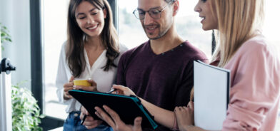 Três pessoas trabalhando e olhando para um tablet, em foto que ilustra post sobre governança digital. Reprodução: nenetus/Envato.