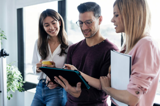 Três pessoas trabalhando e olhando para um tablet, em foto que ilustra post sobre governança digital. Reprodução: nenetus/Envato.