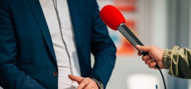Repórteres entrevistando um porta-voz de relações públicas, em foto que ilustra post sobre imagem institucional na gestão pública. Reprodução: microgen/Envato.