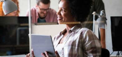 Mulher trabalhando e segurando um tablet. Foto que ilustra post sobre ecossistema de inovação. Reprodução: nd3000/Envato.