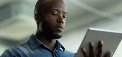 Homem segurando e interagindo com um tablet, em foto que ilustra post sobre PDTIC. Reprodução: YuriArcursPeopleimages/Envato.