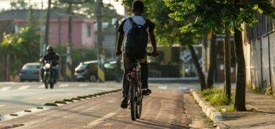Pessoa andando de bicicleta em uma ciclovia. Foto que ilustra post sobre mobilidade verde. Reprodução: wirestock/Envato.