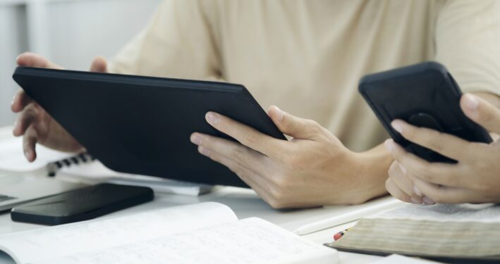 Pessoas usando smartphones e tablets digitais, em foto que ilustra post sobre automatização de contratos. Reprodução: ijeab/Envato.