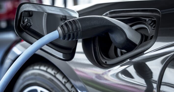 Carro elétrico na estação de carregamento, em foto que ilustra post sobre mobilidade elétrica. Por Rawpixel/Envato.