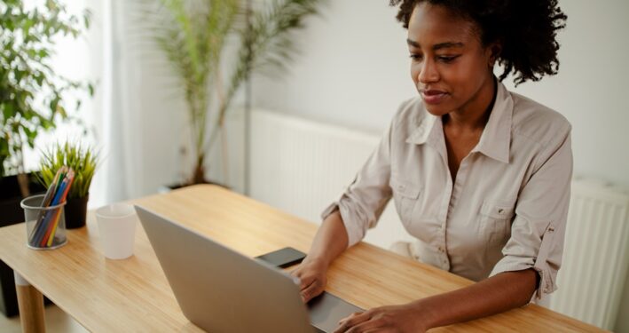 Mulher trabalhando em seu computador. Foto que ilustra post sobre sistema para gestão pública. Reprodução: nebojsa_ki/Envato.