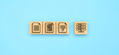 Uma imagem minimalista com blocos de madeira exibindo ícones que representam documentos e servidores, ilustrando post sobre sistema de protocolo. Foto: 1footage/Envato.