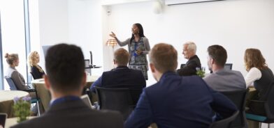 Empresária fazendo apresentação, em foto que ilustra post sobre capacitação profissional. Reprodução: monkeybusiness/Envato.