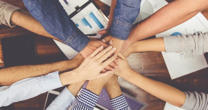 Mãos unidas em trabalho em equipe, em foto que ilustra post sobre corresponsabilidade. Reprodução: GeorgeRudy/Envato.