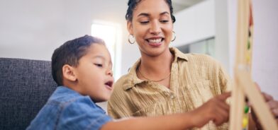 Criança com professora ajudando em lição escolar, foto que ilustra post sobre educação inclusiva. Reprodução YuriArcursPeopleimages/Envato.