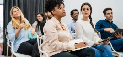 Pessoas atentas durante treinamento, em foto que ilustra post sobre capacitação de servidores. Reprodução: megostudio/Envato.