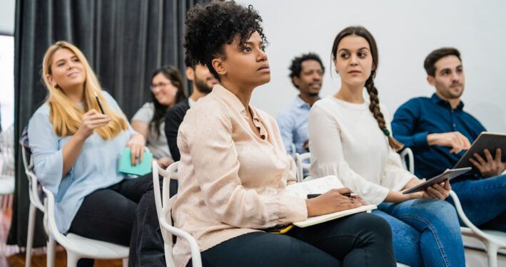 Pessoas atentas durante treinamento, em foto que ilustra post sobre capacitação de servidores. Reprodução: megostudio/Envato.