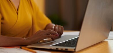 Mulher trabalhando em laptop, em foto que ilustra post sobre comunicados internos. Reprodução: DragonImages/Envato.