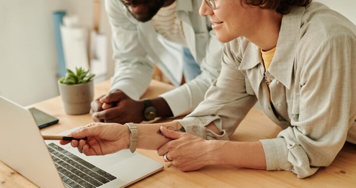 Pessoas trabalhando em laptop, em foto que ilustra post sobre portal institucional no setor público. Reprodução: AnnaStills/Envato.