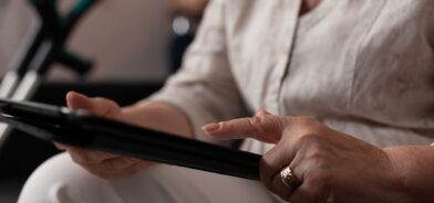 Mão de uma mulher usando a tela do tablet, em foto que ilustra post sobre atos oficiais. Reprodução: DC_Studio/Envato.