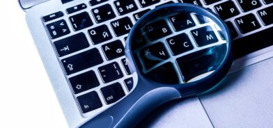 Imagens em close-up da lupa no teclado do laptop. Foto que ilustra post sobre e-SIC. Reprodução: FabrikaPhoto