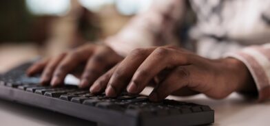 Close-up de um homem escrevendo no teclado do computador, em foto que ilustra post sobre processos previdenciários. Reprodução: DC_Studio/Envato.