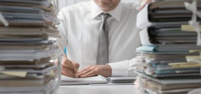 Gerente sobrecarregado de trabalho, em foto que ilustra post sobre processos morosos. Reprodução: stokkete/Envato.