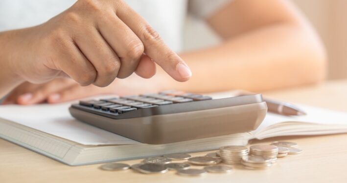 Mulher usando calculadora, em foto que ilustra post sobre Taxa de Fiscalização de Funcionamento (TFF). Reprodução: stockerthings/Envato.