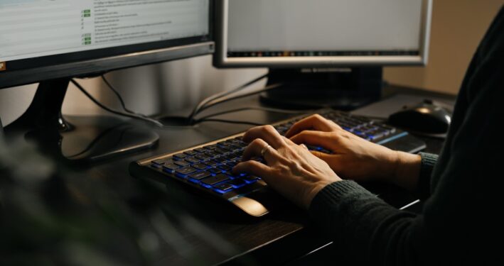 Mulher digitando em computador. Foto que ilustra post sobre assinatura digital em lote. Reprodução: ninelutsk/Envato.