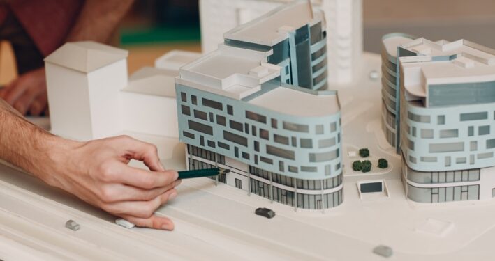 Pessoa com maquete de nova construção. Foto que ilustra post sobre Estudo de Impacto de Vizinhança (EIV). Reprodução: atercorv/Envato.  
