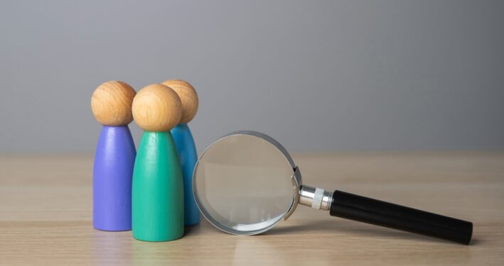 Grupo de pessoas e lupa. Foto que ilustra post sobre processo administrativo disciplinar. Reprodução: iLixe48/Envato.