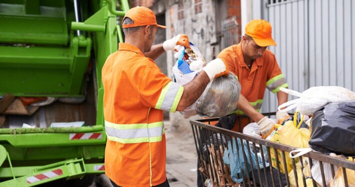 Profissionais de limpeza urbana mantendo a cidade limpa. Foto que ilustra post sobre taxa de lixo. Reprodução: YuriArcursPeopleimages/Envato.
