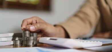 Pessoa empilhando moedas, em foto que ilustra post sobre transferências voluntárias. Reprodução: indypendenz/Envato.
